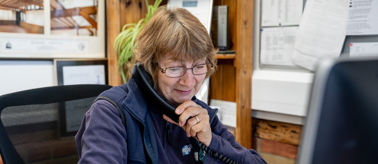 Sue Grace answering the telephone at Stable Close Equine Practice